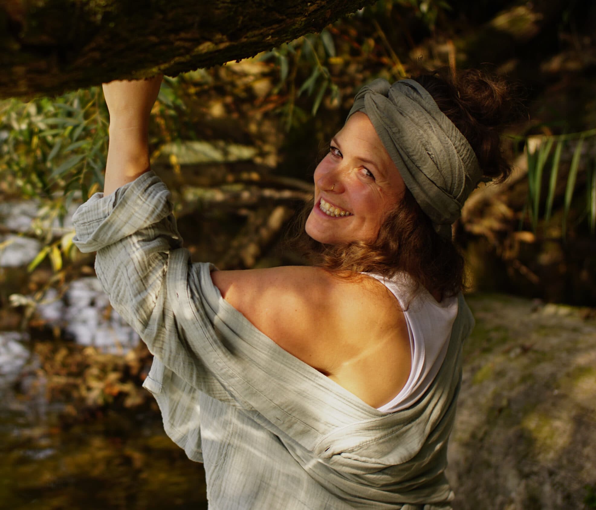 Miriam Faber blickt lächelnd über die Schulter, im Hintergrund Bäume am Fluss